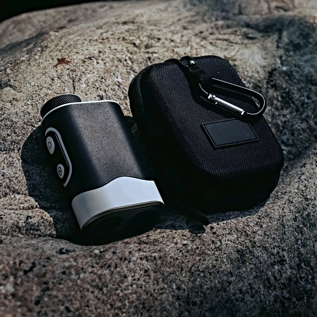 SEASONS rangefinder beside its zip carrying case with carabiner clip, on granite