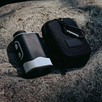 SEASONS rangefinder beside its zip carrying case with carabiner clip, on granite